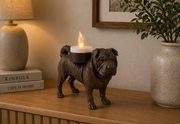 Bruine Shar Pei hond waxinelichthouder op houten kast in warme huiselijke woonkamer setting.