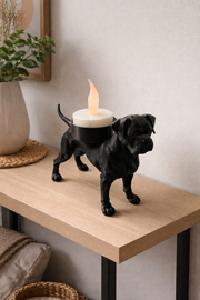 Close-up van een zwarte boxer waxinelichthouder op houten tafel met waxinelichtje.