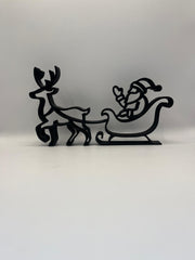 Close-up van de 3D-geprinte Xmas Deco – Arrenslee in zwart PLA met rendier en kerstman, op lichte achtergrond.