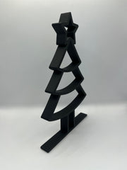 Zwart minimalistisch kerstboomornament in schuin zijaanzicht met moderne vormgeving.