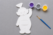 Complete Tinky Winky DIY knutselset met verfbaar figuur, penseel en verfkleuren paars, geel en grijs.