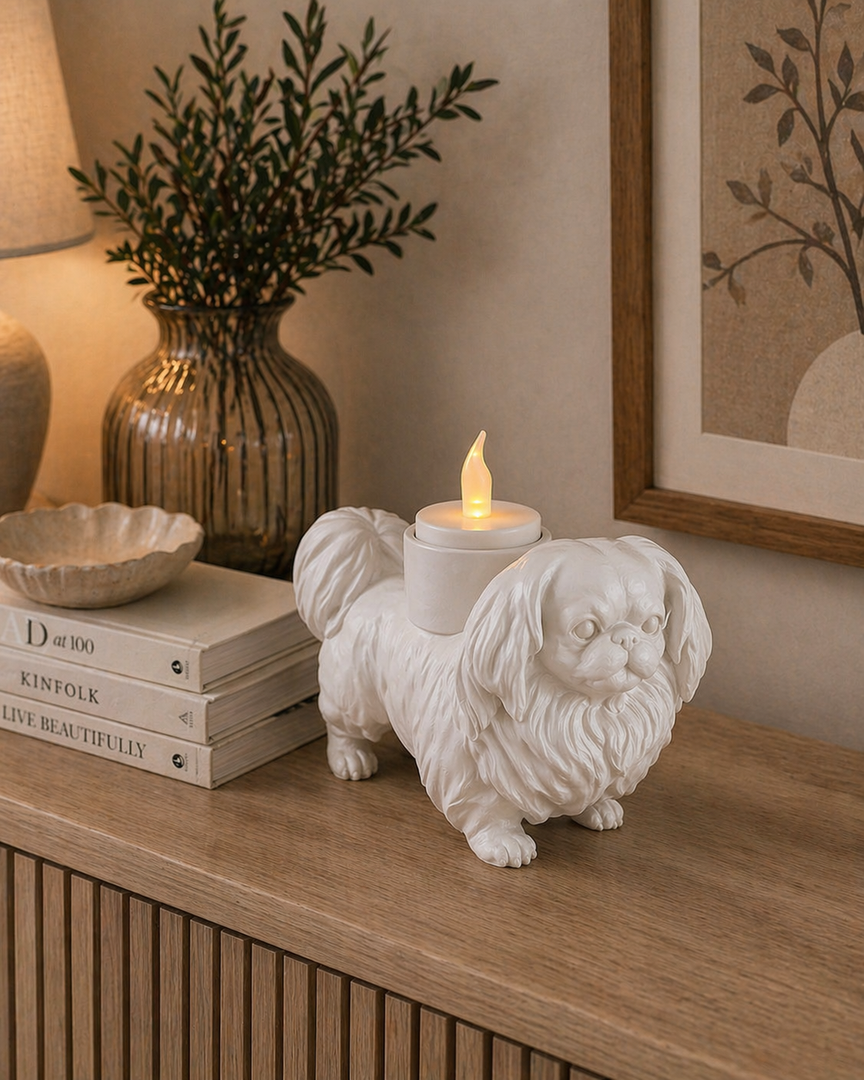 Matte witte Pekingees hond waxinelichthouder met LED-waxinelichtje op houten kast in warme huiselijke omgeving.