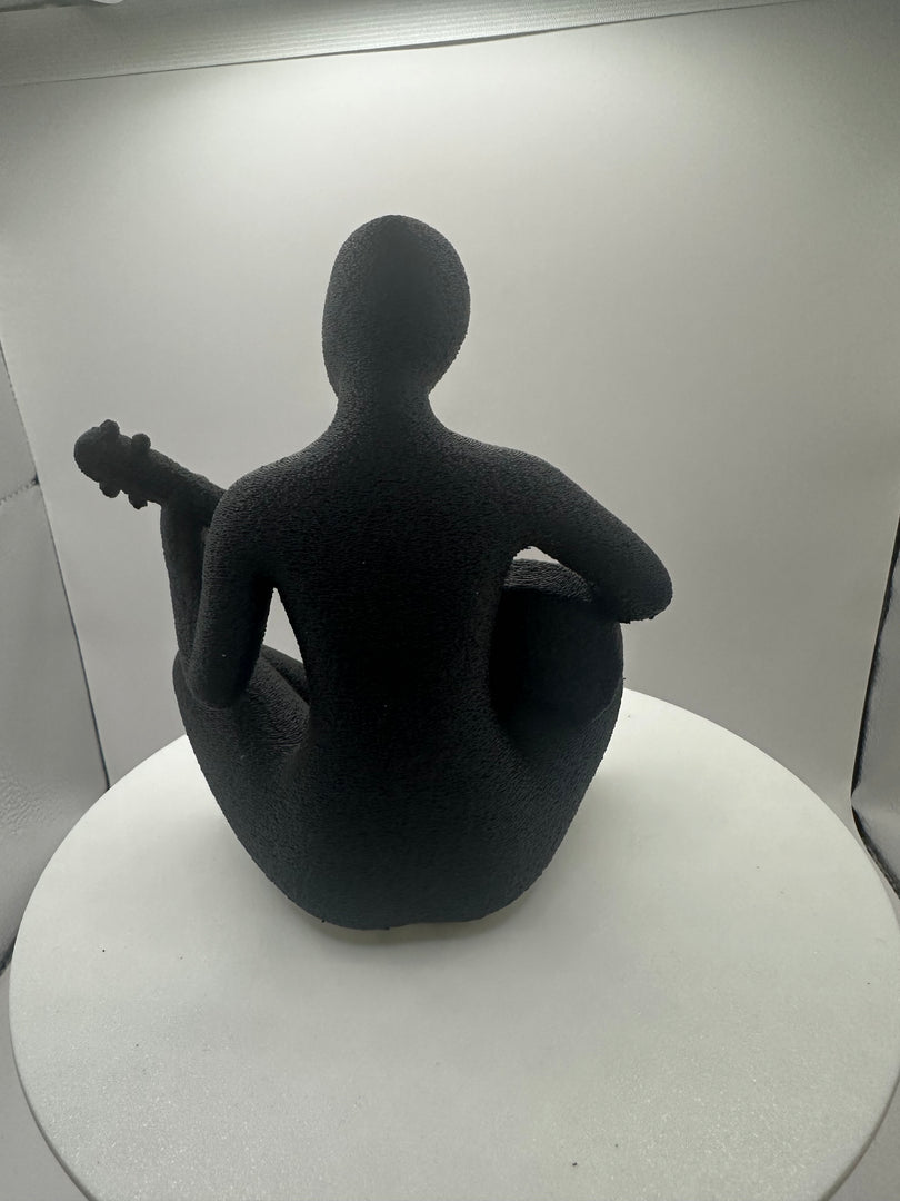 Achteraanzicht van abstracte gitaarspeler sculptuur, minimalistisch zwart decoratiebeeld van 15 cm.