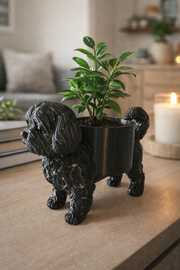 Zwarte bloempot in hondenvorm met plantje op vensterbank in modern interieur