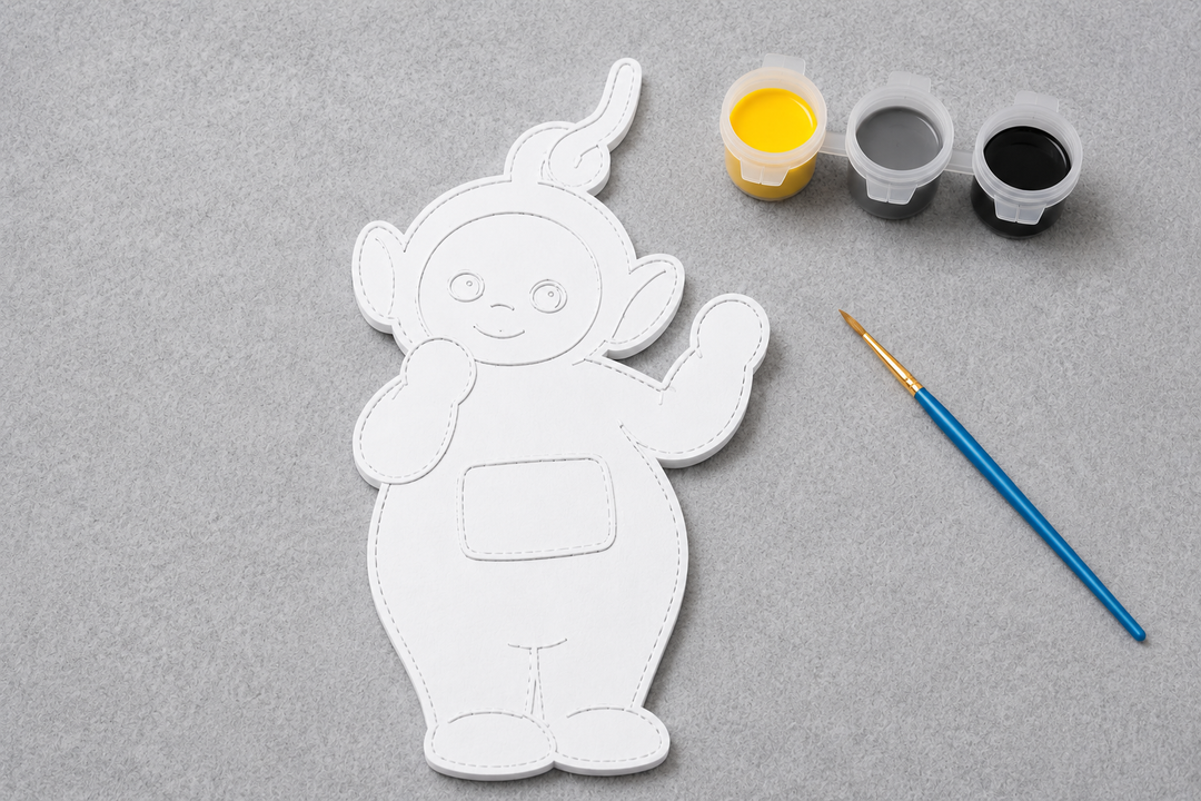 Verfbaar Laa-Laa figuur met penseel en verfkleuren geel, grijs en zwart uit de Teletubbies DIY-knutselset van Hunoba Creative.