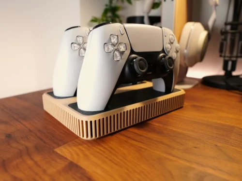 Gamecontroller geplaatst in een zwarte wandhouder, zijaanzicht op een witte muur.