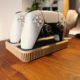 Gamecontroller geplaatst in een zwarte wandhouder, zijaanzicht op een witte muur.