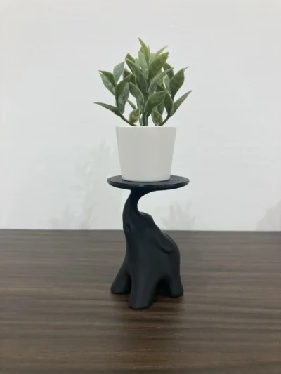 Beeld van een olifant op een decoratieve standaard, geschikt als kaarsenhouder of plantenstandaard.