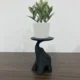 Beeld van een olifant op een decoratieve standaard, geschikt als kaarsenhouder of plantenstandaard.