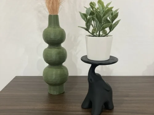 Stijlvol beeld van een olifant in majestueuze houding op een stevige standaard, geschikt als kaarshouder of plantenstandaard.
