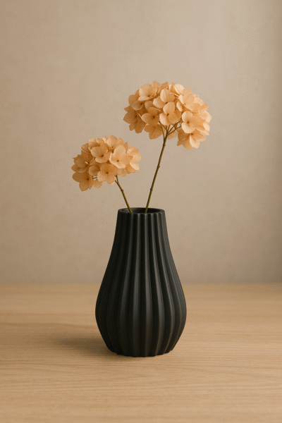 Zwarte ribbelvaas Siervaas Elin met perzik-hortensia op een houten tafel